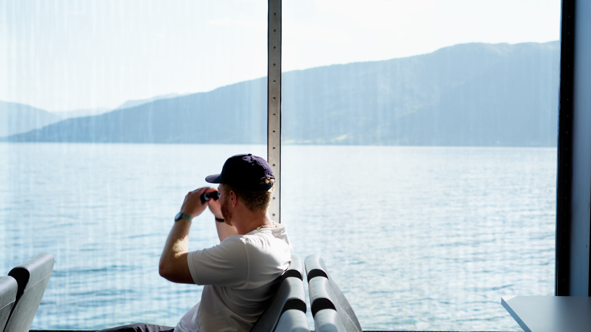 Traveler glassing a fjord through a ferry window